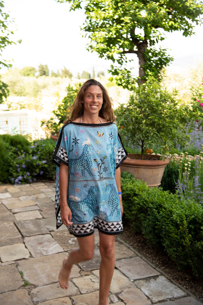 Frau im hellblau cyan / bunten Strandkleid