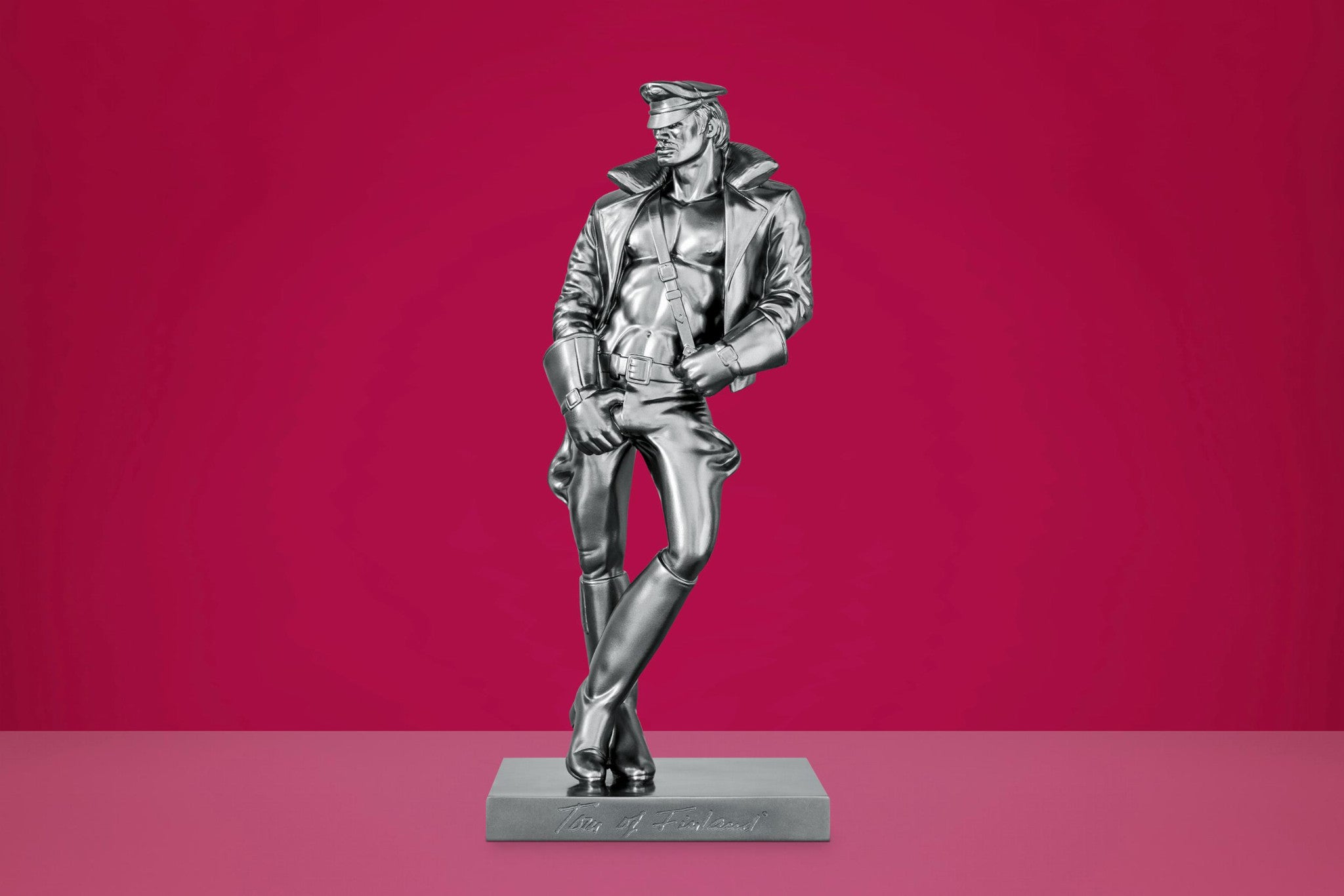 Buchstütze „Durk“ aus Gusskunstharz in metallischer Optik auf pinkem Hintergrund