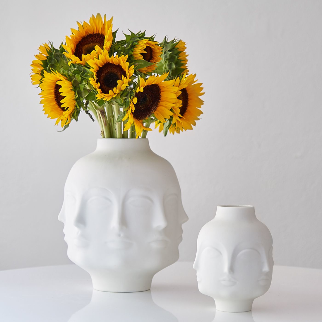 Weiße Design-Vase mit surrealistischen Gesichtszügen.