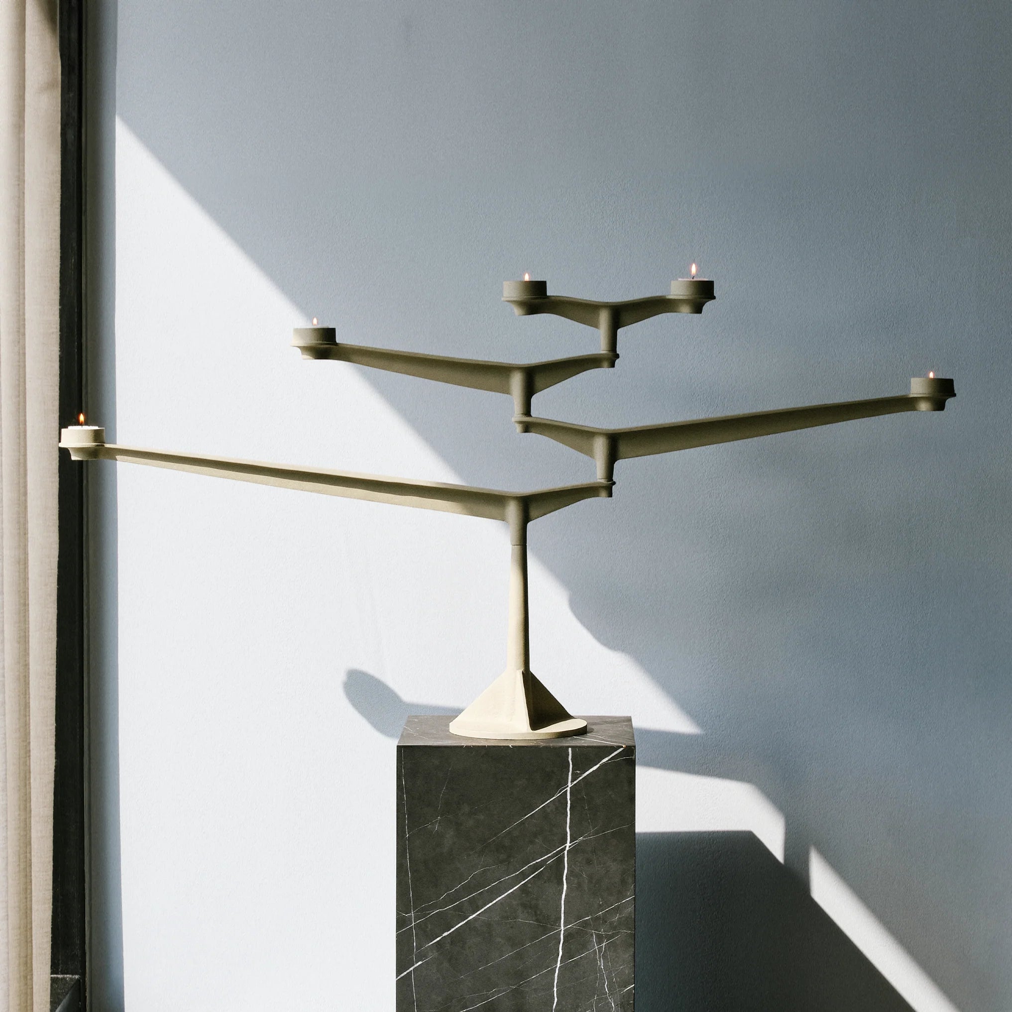 Large Spin Candelabra Putty auf Tisch arrangiert als dekoratives Centerpiece mit Stabkerzen und Teelichtern
