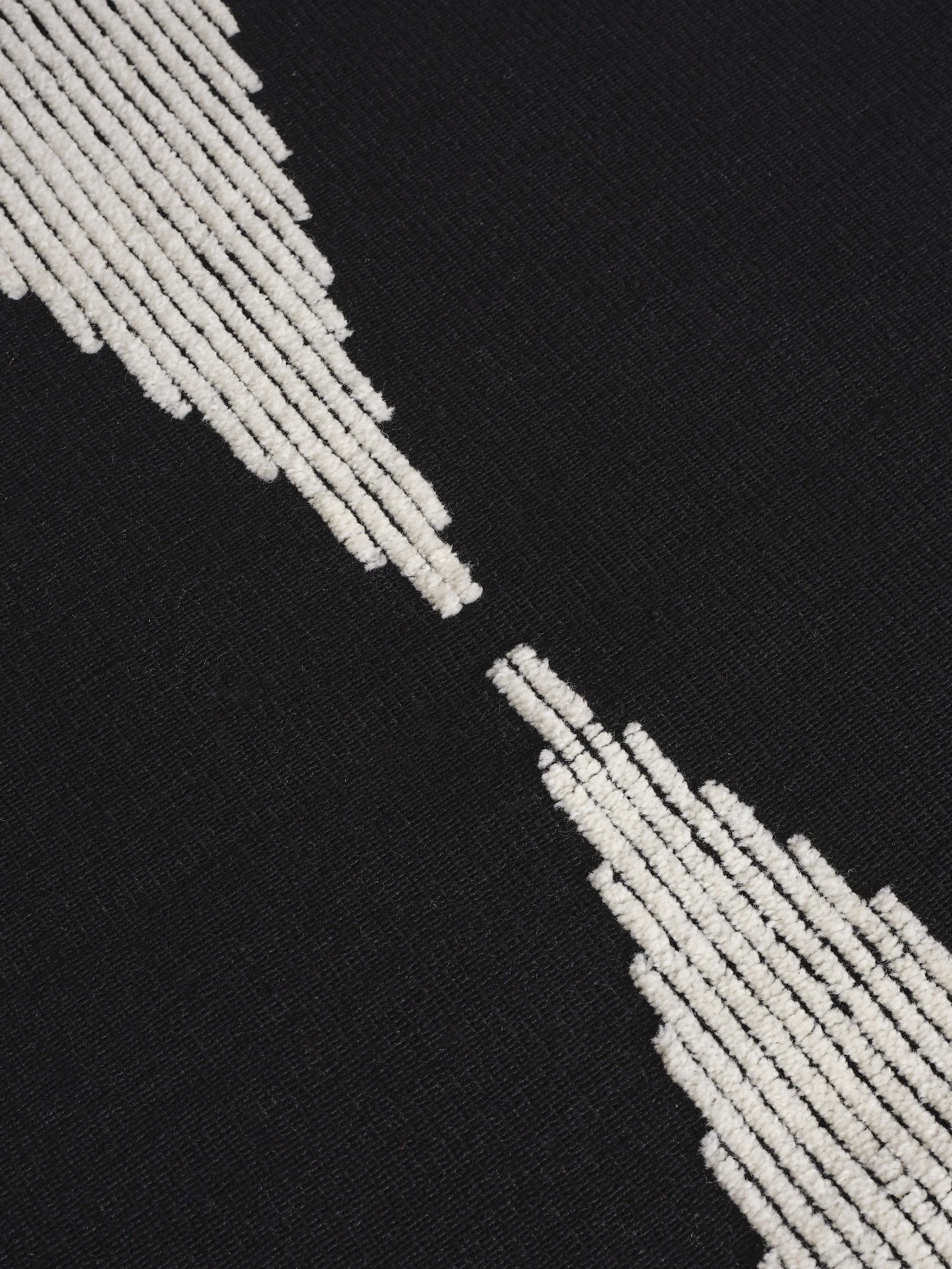 Detailaufnahme der kontrastreichen Florstruktur des Wedge Rug aus Naturwolle