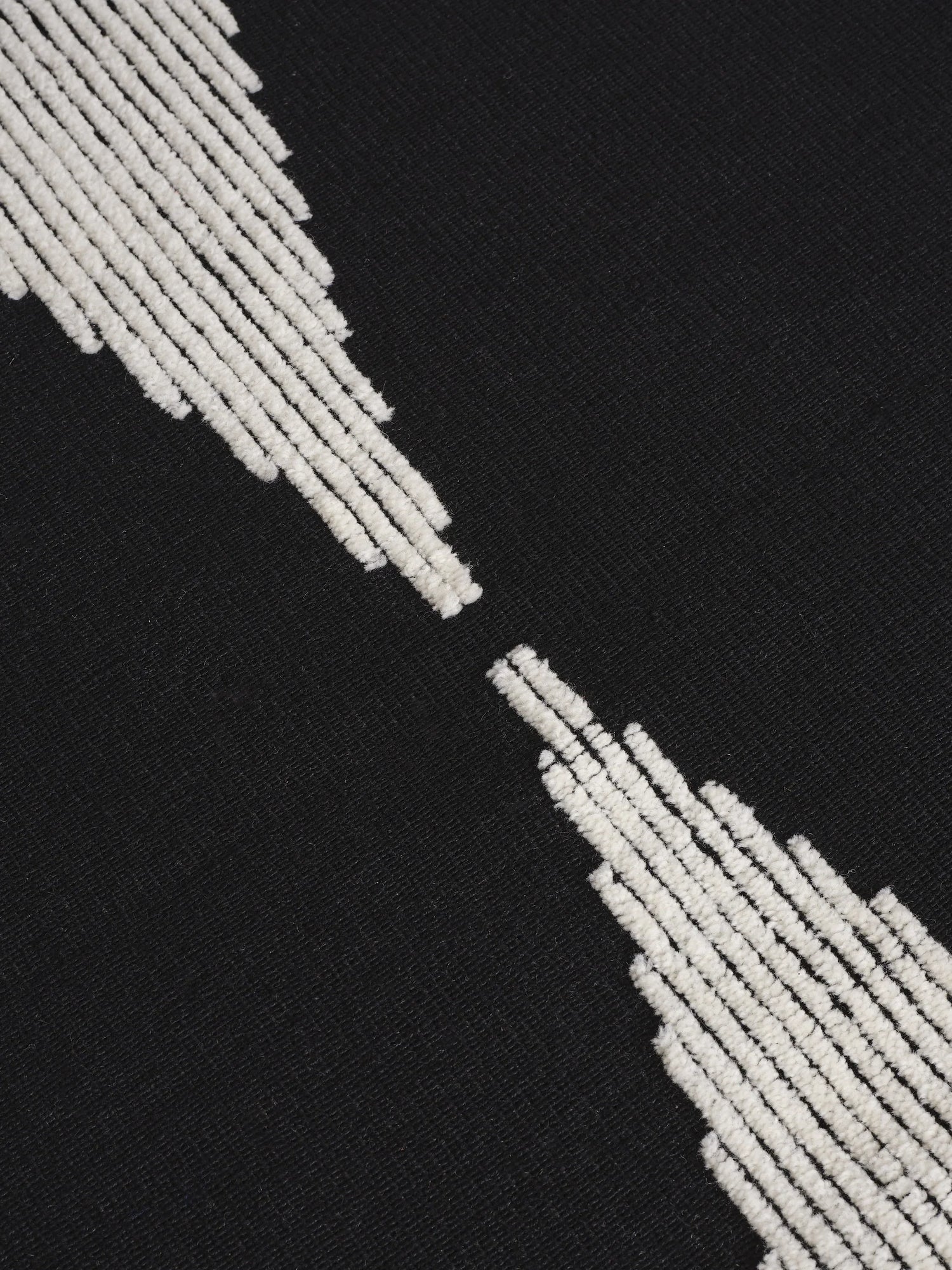 Detailaufnahme der kontrastreichen Florstruktur des Wedge Rug aus Naturwolle