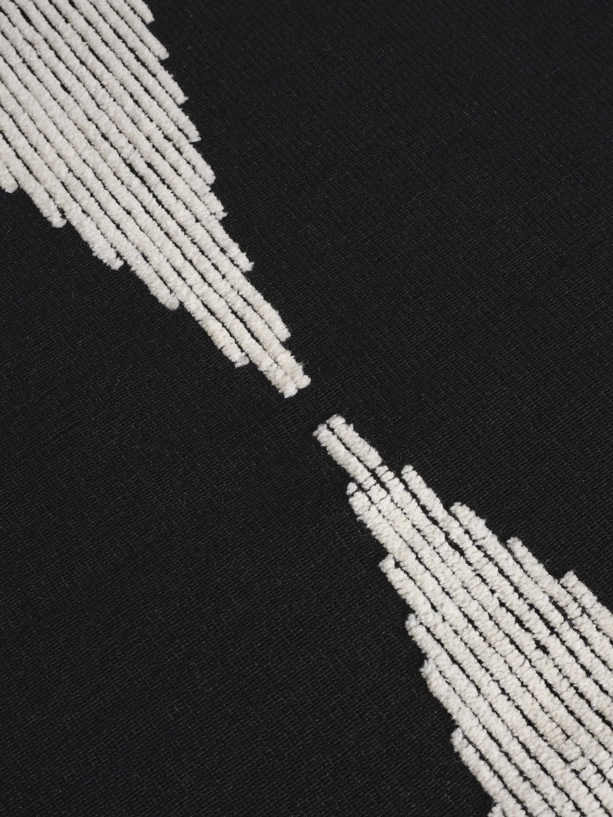 Detailaufnahme der kontrastreichen Florstruktur des Wedge Rug aus Naturwolle