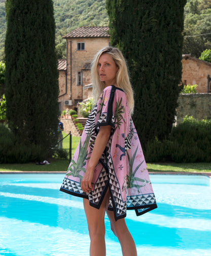 Frau im rosa rosé / bunten Strandkleid am Pool