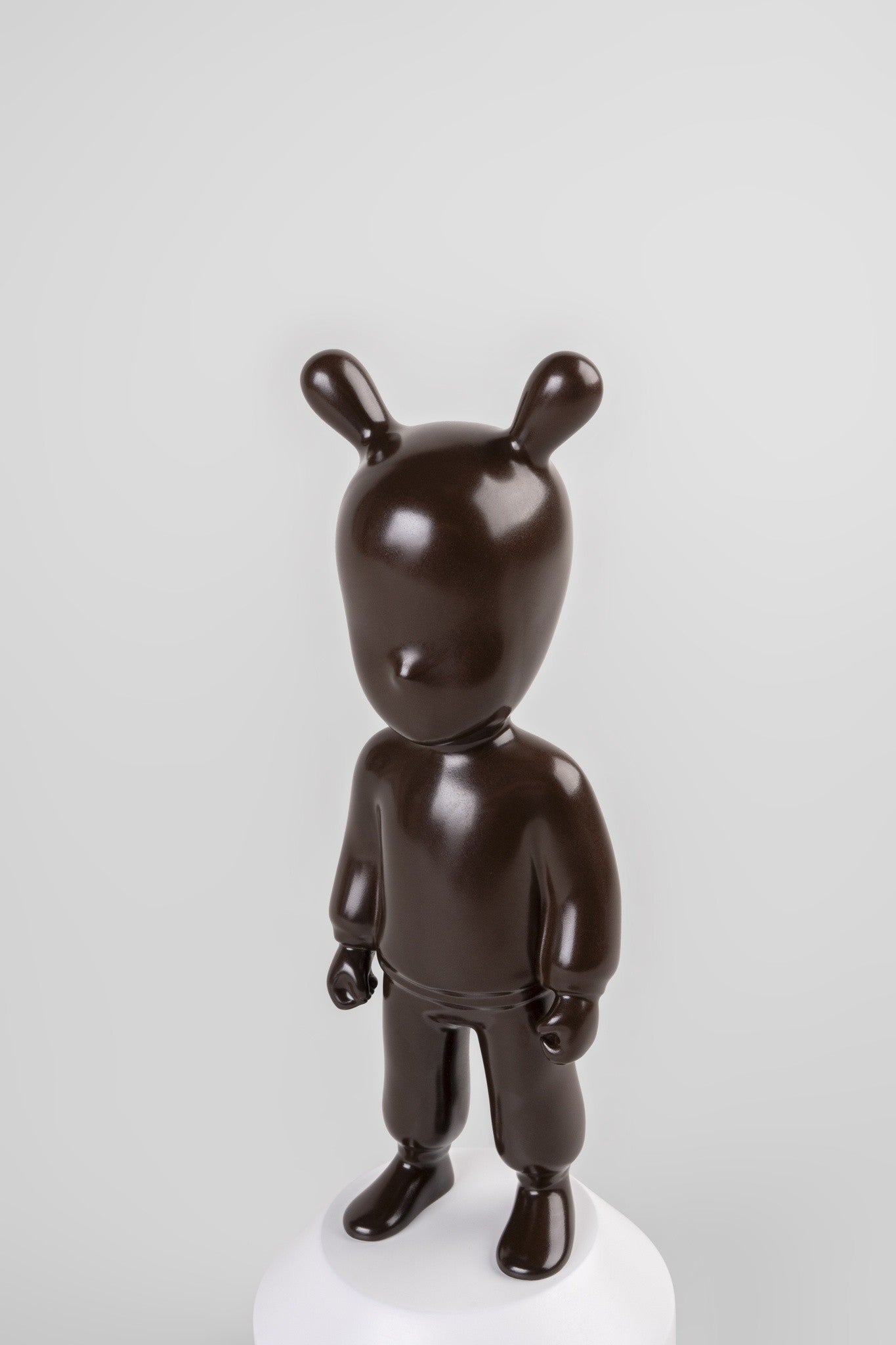 Porzellanfigur auf geometrisch weißem Sockel in Kontrastoptik